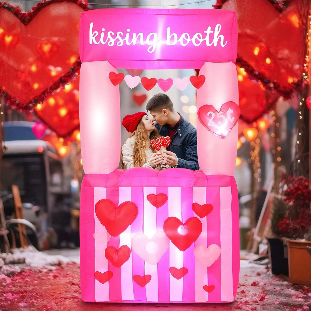 Pink kissing booth inflatable with a couple posing in the window and hearts on the counter