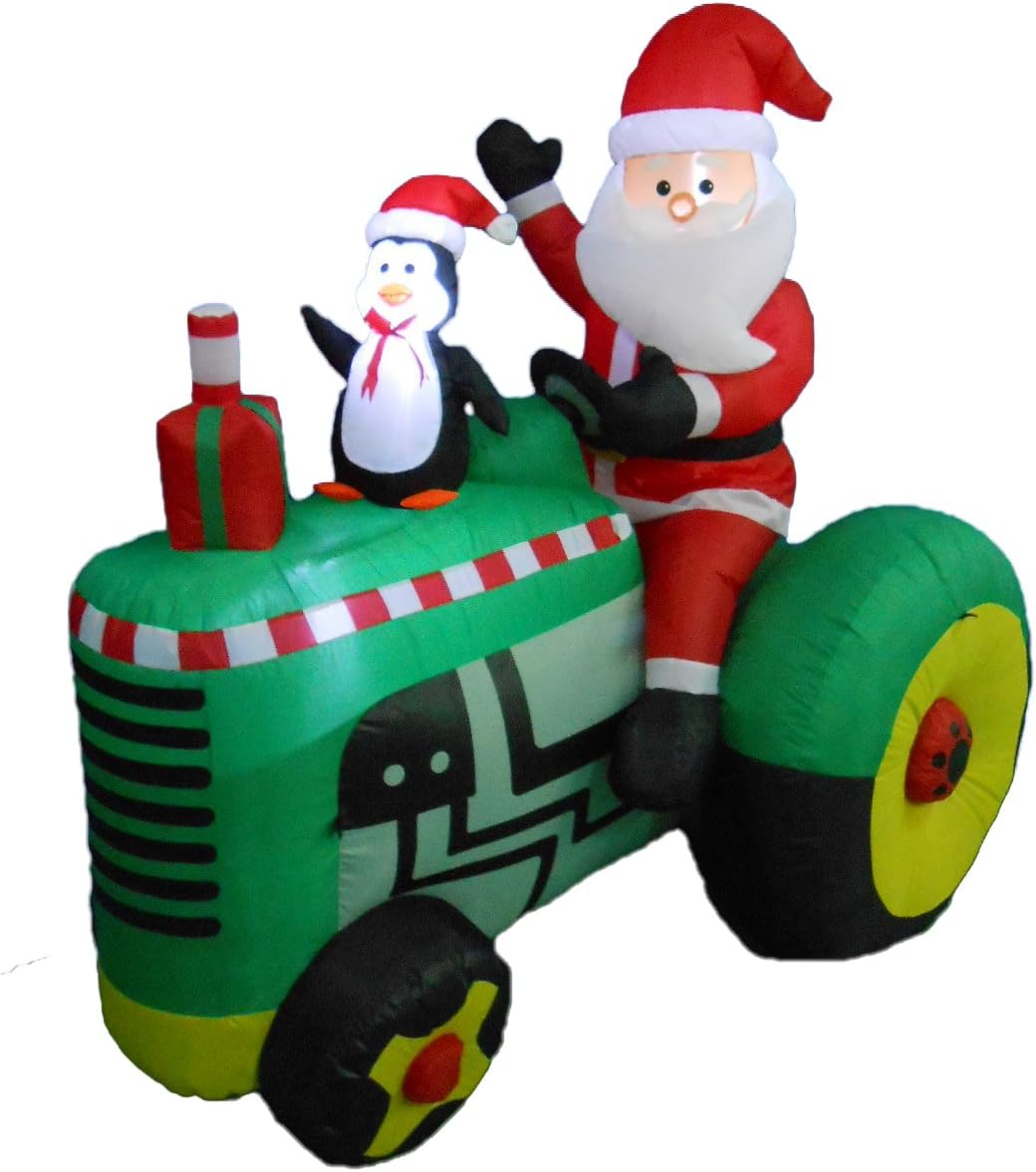 Santa and a penguin riding a green tractor inflatable