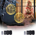Two warm white battery light balls hanging outside a window with remotes and battery boxes