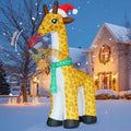Tall giraffe inflatable in a Santa hat and scarf nodding in a snowy yard