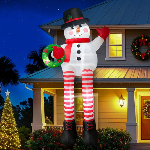 Snowman inflatable with red and white striped legs sitting on a porch roof holding a wreath