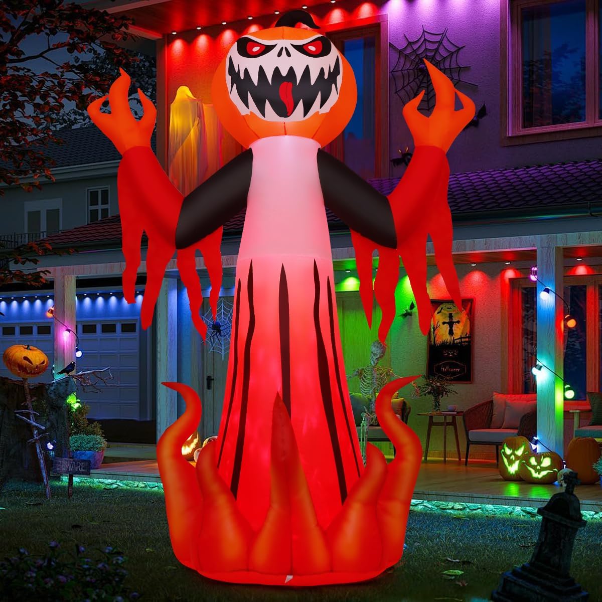 Pumpkin-headed demon inflatable with claws rising from flames in front of a house at night