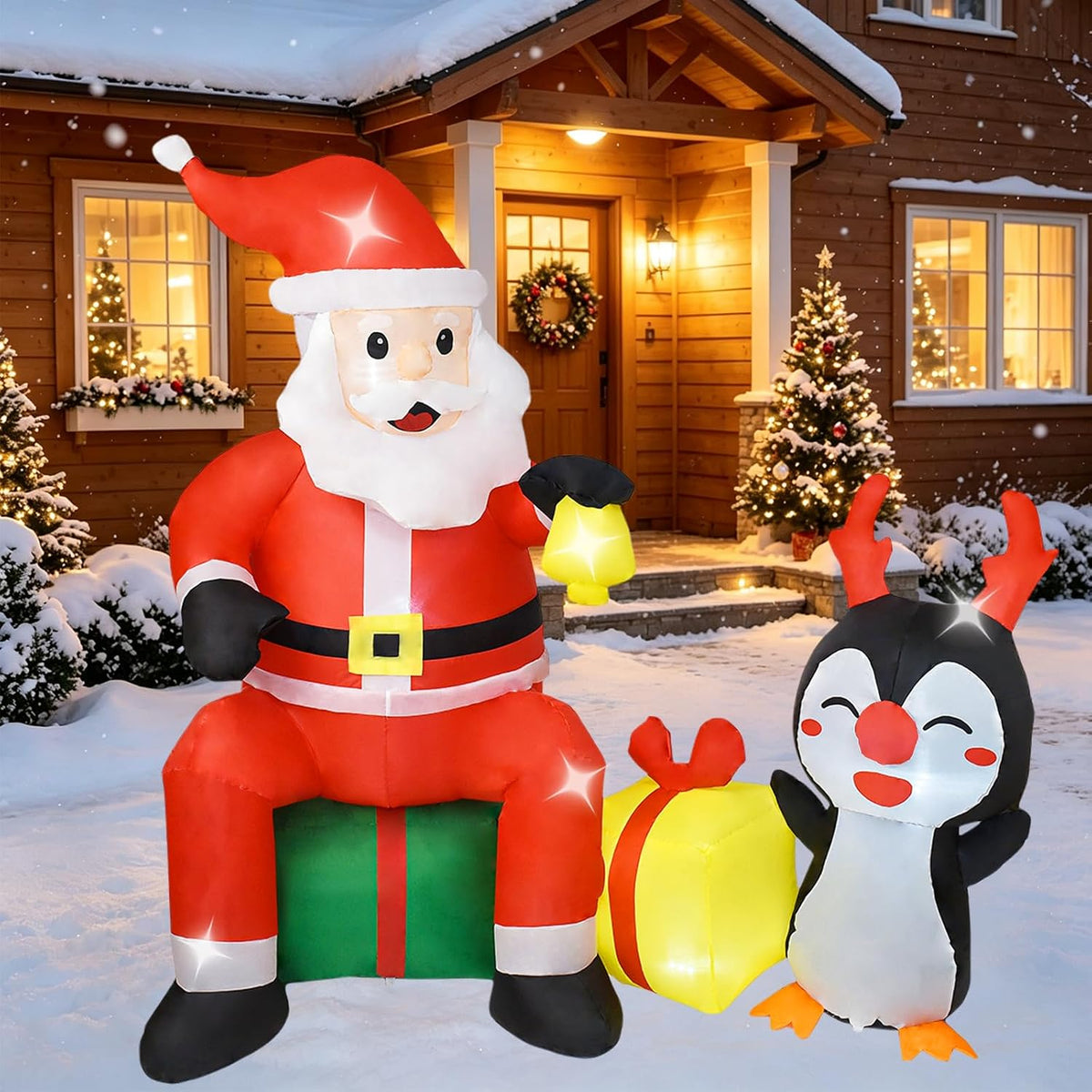Santa sitting on gifts holding a lantern next to a penguin with antlers in a snowy yard