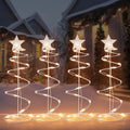Four warm white spiral Christmas tree lights with star toppers in a row
