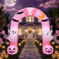 Pink Halloween arch inflatable with a bow, ghosts and jack-o'-lanterns over a front path at night