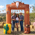 Brown Wild West inflatable arch with a longhorn skull and three people in cowboy hats posing under it