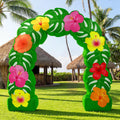 Green tropical arch inflatable covered in leaves and hibiscus flowers on a lawn with palm huts