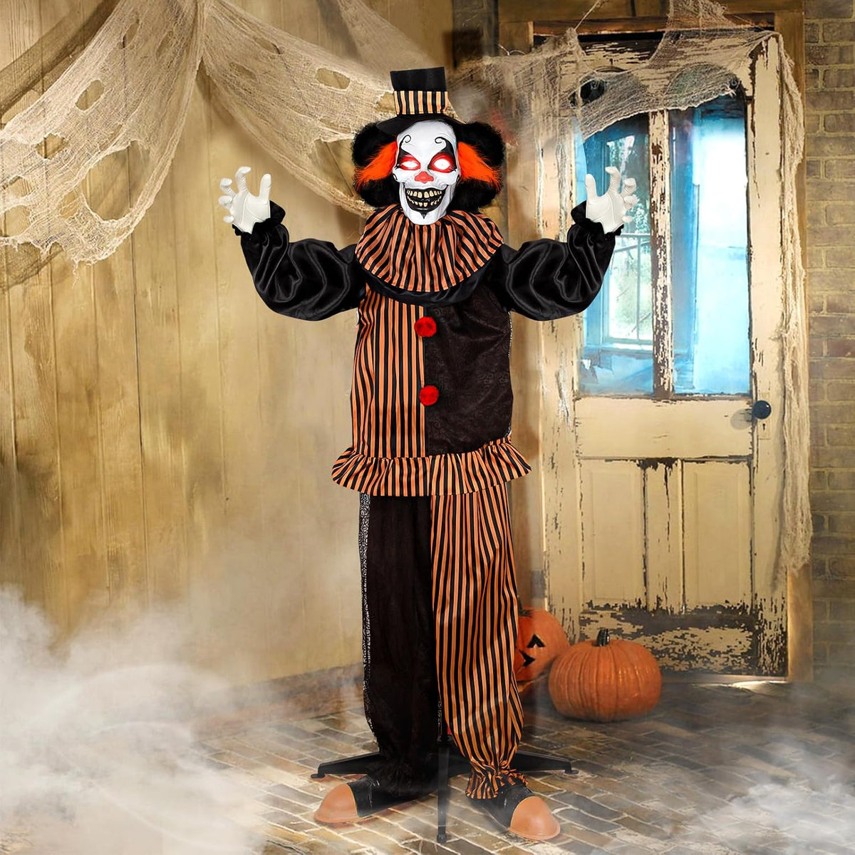 Creepy clown prop in a striped suit and top hat standing in a foggy doorway